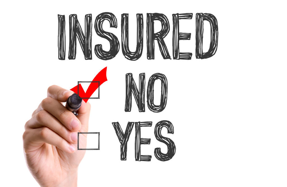 Hand marking red checkmark next to "INSURED" with "NO" and "YES" checkbox options